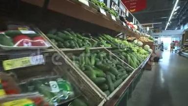 超市货架上有许多不同的蔬菜。 黄瓜，卷心菜，萝卜，西红柿。