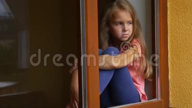 体贴冷漠的女孩望着窗外。 通过窗口查看