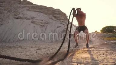 男运动员在<strong>沙滩</strong>上推-UPS，用绳子打地面，在<strong>沙滩</strong>上<strong>阳光</strong>下循环训练。
