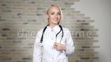 一位年轻漂亮的女<strong>医生</strong>的肖像，脖子上戴着一个电话显示器，<strong>看</strong>着镜头微笑。卫生保健意识。4公里