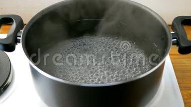 厨房电炉上的平底<strong>锅</strong>里的水会随着气泡<strong>沸腾</strong>。