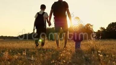 大自然中一个快乐的旅游家庭：爸爸和他的两个儿子在日落时背着背包。旅游的概念