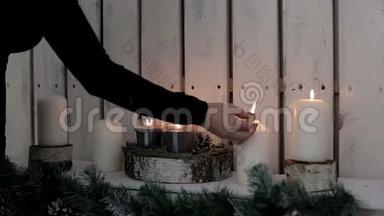 一位女士点燃蜡烛。 寒假的温暖和气氛