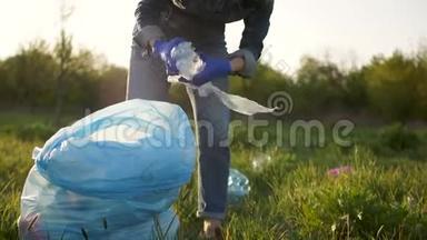 女<strong>志愿者</strong>在公园里收集塑料垃圾。 女孩穿着牛仔<strong>服</strong>，穿着蓝色防护衣