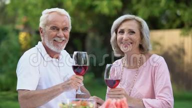 带着酒杯微笑的老夫妇庆祝结婚纪念日，家庭传统