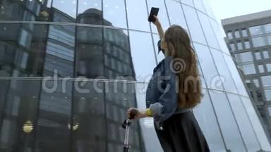 可爱的游客用智能手机相机拍摄未来主义<strong>商业中心</strong>的照片。