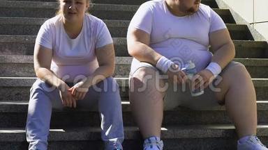 胖乎乎的男人和女人在楼梯上<strong>辛苦</strong>锻炼后休息，呼吸急促
