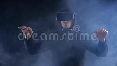 人获得使用VR头套在黑暗烟雾背景的经验。 增强现实设备创建虚拟空间。