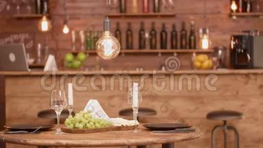 一张木制<strong>圆桌</strong>，放在空餐厅，里面有奶酪和葡萄开胃菜