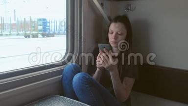 疲惫的年轻女子在火车上用手机看视频。