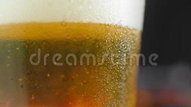 宏观拍摄的一个啤酒杯与冷啤酒，气泡上升的玻璃。 慢动作啤酒气泡..