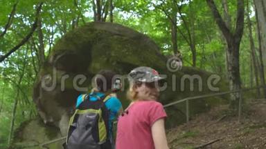 徒步旅行团的游客在丛林野生自然公园的山上。 带背包的美女拍照