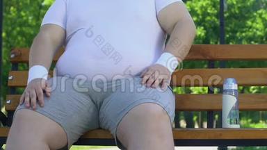 懒汉坐在长凳上<strong>抚摸</strong>着他的大胖肚子，而不是去运动