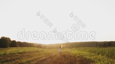 日落时分，带着野花束的女孩在田野里<strong>奔跑</strong>，在草地上享受<strong>自由</strong>，微笑着