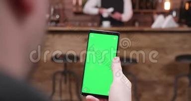 男人用绿色屏幕在手机上滑动
