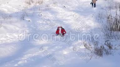 穿着<strong>红色</strong>夹克的小女孩在<strong>冬季</strong>公园里从雪山上滑下雪橇。女孩欢笑着。