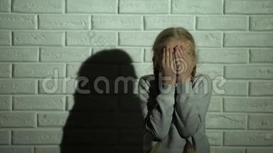惊恐的小女孩双手闭眼，目睹家庭暴力