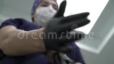 外科医生戴上无菌橡胶手套进行复杂的外科手术。 外科手术