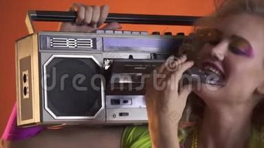 金发女人带着复古的造型，把一盒磁带放进老式录音机里
