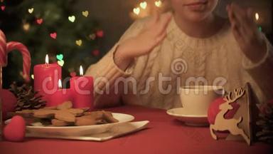 可爱的女孩闻着热可可、圣诞装饰和饼干