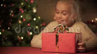 女士送给兴奋的女孩圣诞礼物，节日快乐，树闪闪发光