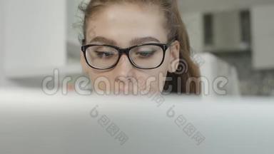 疲惫的女孩看着笔记本上的文字，看着笔记本屏幕，准备考试