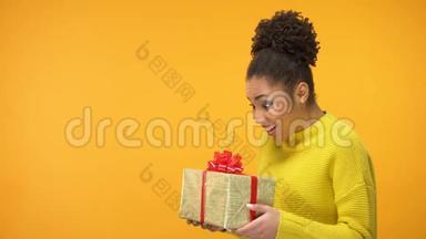 惊喜的黑女人拿着生日礼物盒，意外的礼物，背景
