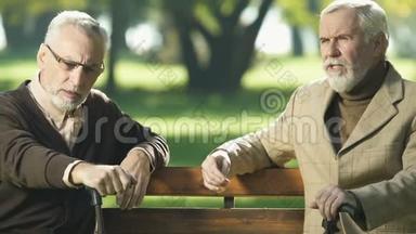 退休的绅士在公园里聊天，试图回忆，衰老的记忆障碍