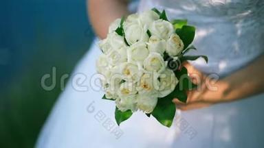 新娘手里拿着一大束漂亮的结婚花束，<strong>抚摸</strong>着花束里的花，用手指<strong>抚摸</strong>着