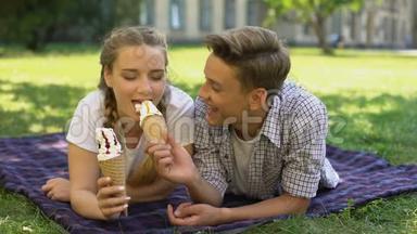 有趣的青少年用冰淇淋互相<strong>喂饭</strong>，躺在格子布上，到处胡闹