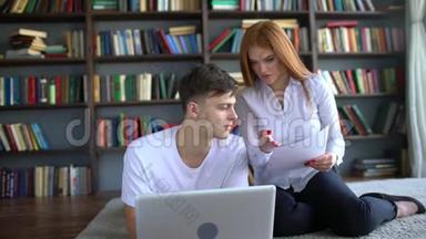 男女学生在图书馆学习和使用笔记本电脑。 两个学生讨论桌面，集思广益