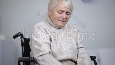 轮椅上的老年妇女按摩膝关节疼痛，健康问题