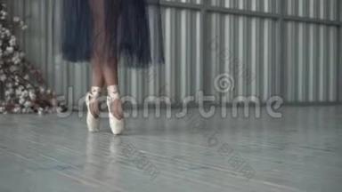 芭蕾舞演员的特写`穿着尖角鞋的腿，紧身衣和网裙在舞蹈室的尖角上跳舞。 芭蕾舞