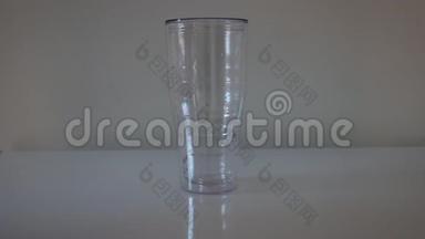 咖啡师手把冰块放进塑料杯的特写镜头。 一个酒吧服务员把一个水罐里的冰块倒入外卖