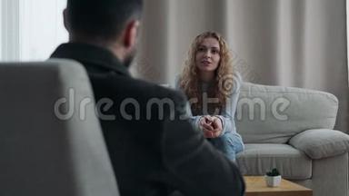 坐在沙发上跟他的治疗师说话的女人