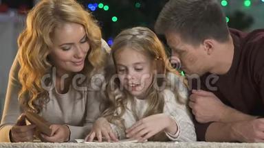 快乐的父母帮助可爱的女孩写信给圣诞老人，相信奇迹