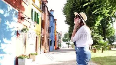 威尼斯，布鲁诺，意大利-2018年7月7日：年轻的女人，戴太阳镜的女孩，帽子，短裤，打电话，微笑