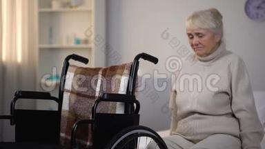 在康复中心坐在<strong>轮椅</strong>旁的沙发上，心烦意乱的<strong>老年</strong>妇女