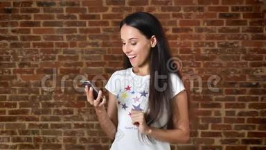 年轻可爱的女孩使用智能<strong>手机</strong>，<strong>刷</strong>卡，显示屏幕在相机，如标志，色度键，砖墙在背景