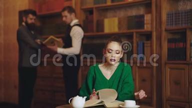 <strong>图书馆</strong>里的女<strong>人看书</strong>，从杯子里喝咖啡。 有可爱女孩和男<strong>人</strong>的文学咖啡馆。 学生生活