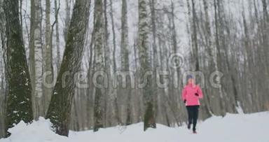 一个年轻的女人在冬天的森林里晨跑，累了，停下来休息，继续跑。 他恢复了<strong>体力</strong>