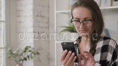 白种人的女商人正微笑着看着手机屏幕，在家里投资。