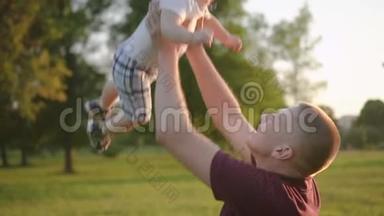 美<strong>国父</strong>亲带着微笑把婴儿抛起来，有时间在露天。
