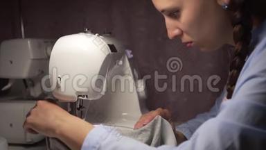 女人用灯把衣服缝在缝纫机上。 时尚，创造和剪裁。