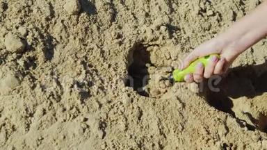 <strong>一只手</strong>拿着<strong>一</strong>把小小的花园铲子，从<strong>一</strong>大堆沙子里收集沙子