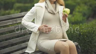 准妈妈吃苹果，轻轻抚摸肚子，<strong>母爱</strong>，关怀