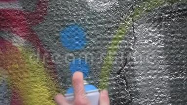 街头涂鸦艺术家在混凝土墙上用喷漆制作艺术。 街头艺术、城市文化