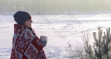 这个女孩在外面冬天喝茶。 寒冷的霜天。 热饮温暖双手