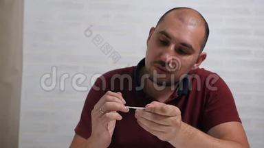 一个可敬的秃头用一种特殊的药物治疗他的指甲，以治愈真菌。 家中手部真菌治疗