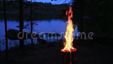 瑞典或芬兰圆木蜡烛靠近<strong>黄昏</strong>湖。 <strong>夜晚</strong>从木头里燃烧起来。